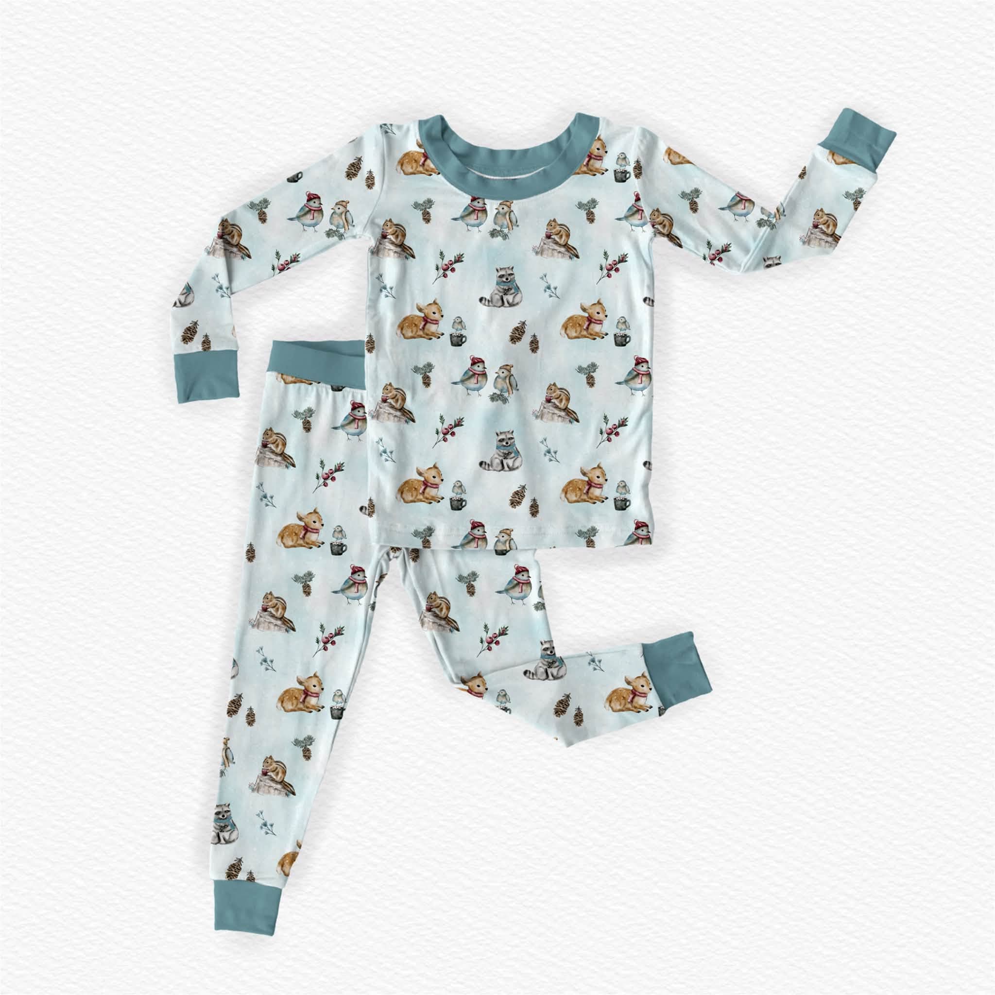 Children's woodland bamboo pajama featuring a winter woodland theme. Hand drawn details of woodland animals like fawn, raccoon, chipmunks and songbirds dressed in scarf and beanies sharing hot cocoa.